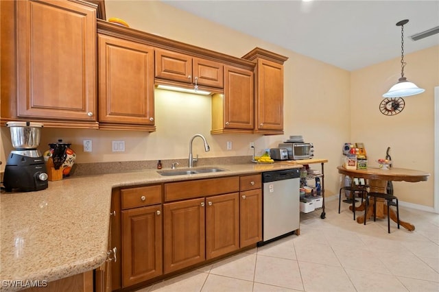 kitchen featuring visible vents, a sink, brown cabinetry, dishwasher, and hanging light fixtures