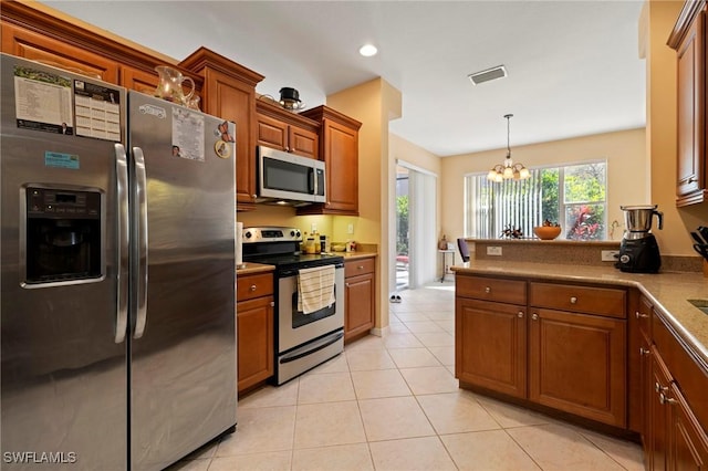 kitchen featuring visible vents, light tile patterned floors, appliances with stainless steel finishes, an inviting chandelier, and brown cabinetry