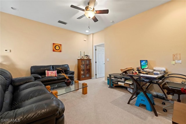 carpeted living area featuring visible vents and a ceiling fan