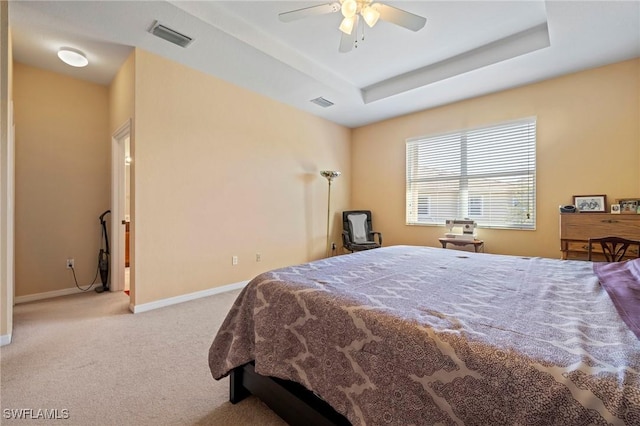 bedroom featuring visible vents, carpet, a raised ceiling, and baseboards