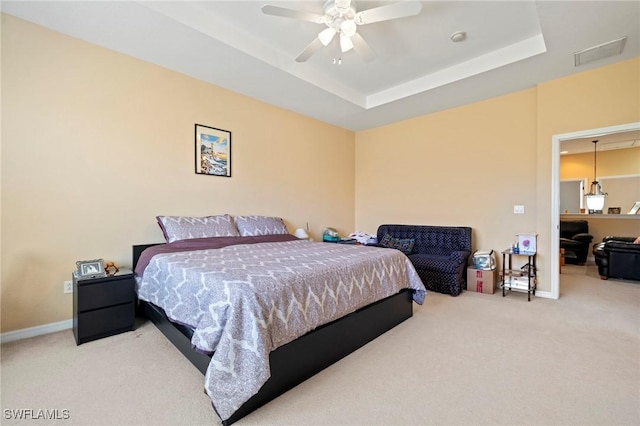 bedroom featuring a raised ceiling, carpet flooring, and visible vents