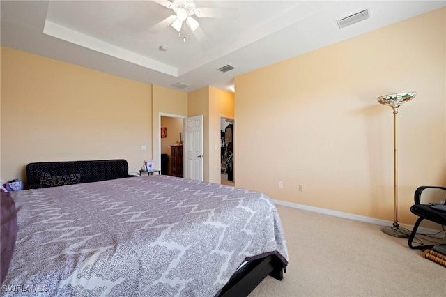 bedroom with visible vents, baseboards, carpet, and a tray ceiling