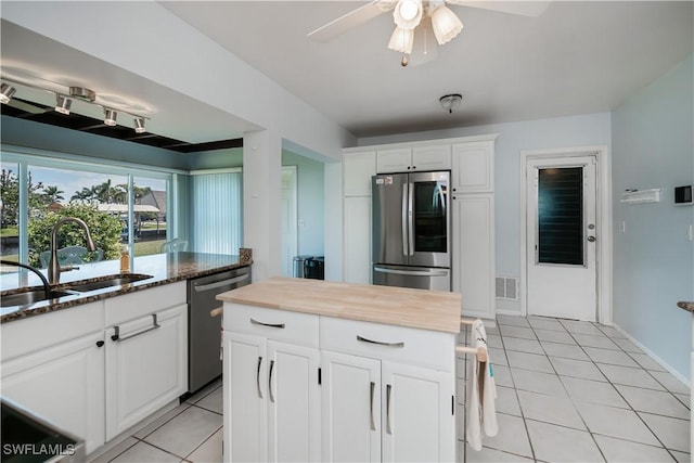 kitchen featuring light tile patterned floors, visible vents, ceiling fan, a sink, and appliances with stainless steel finishes