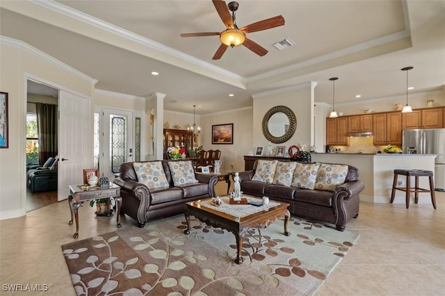 living room with a tray ceiling, visible vents, a ceiling fan, and crown molding