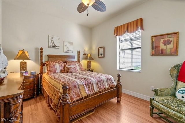 bedroom featuring baseboards, light wood-style flooring, and a ceiling fan