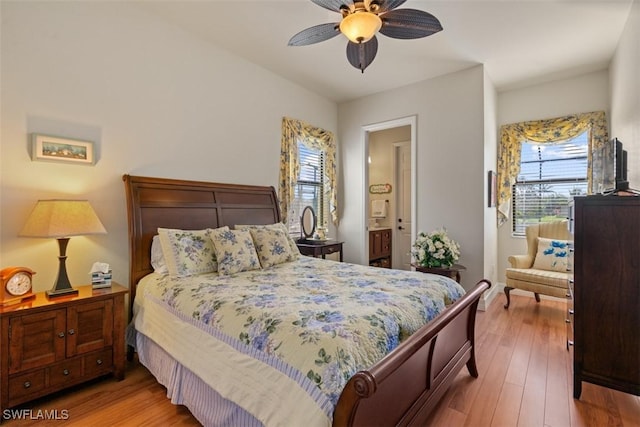 bedroom with ensuite bath, ceiling fan, and wood-type flooring