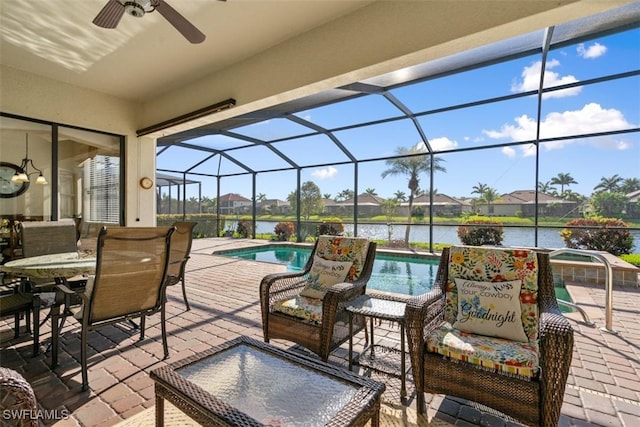 view of patio with a jacuzzi, a water view, a lanai, an outdoor pool, and a ceiling fan