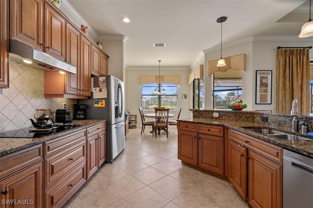 kitchen with a sink, brown cabinets, under cabinet range hood, and stainless steel appliances