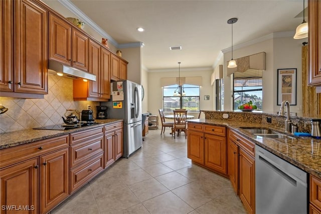 kitchen with under cabinet range hood, brown cabinets, appliances with stainless steel finishes, and a sink