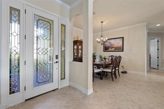 foyer entrance featuring arched walkways, baseboards, crown molding, and an inviting chandelier