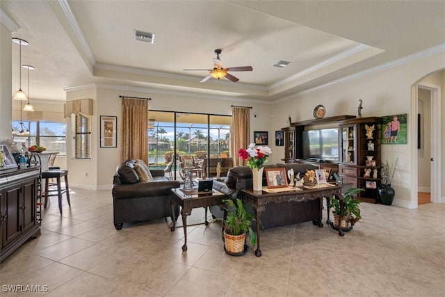 living room featuring a tray ceiling, a healthy amount of sunlight, visible vents, and ceiling fan