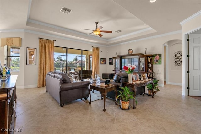 living room with visible vents, a raised ceiling, arched walkways, and a ceiling fan