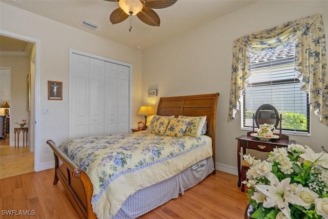 bedroom featuring a ceiling fan, baseboards, visible vents, a closet, and light wood-type flooring