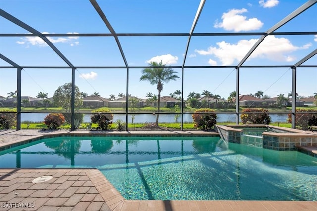 view of pool featuring a patio area, glass enclosure, a pool with connected hot tub, and a water view