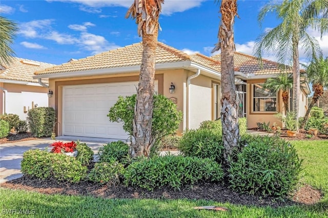 8339 Langshire Way, Fort Myers, FL 33912 - view of front of home with a garage, a tiled roof, driveway, and stucco siding