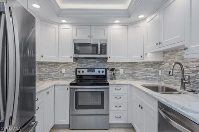 kitchen featuring white cabinetry, stainless steel appliances, crown molding, and a sink