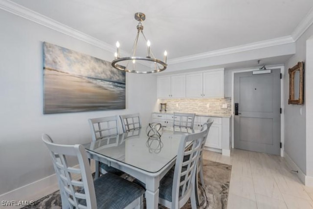 dining space featuring baseboards, an inviting chandelier, and ornamental molding