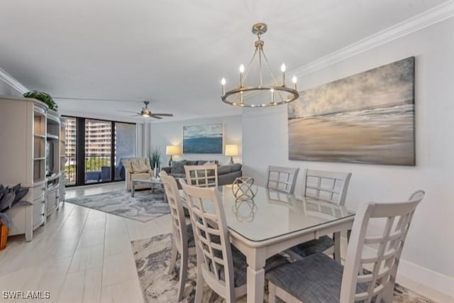 dining room featuring a wall of windows, crown molding, ceiling fan with notable chandelier, and baseboards