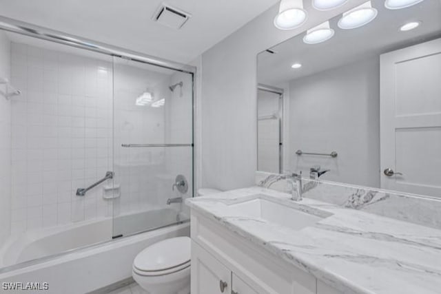 bathroom featuring visible vents, toilet, vanity, and bath / shower combo with glass door