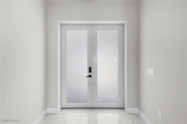 doorway to outside featuring baseboards and marble finish floor