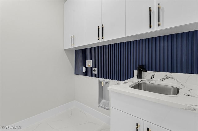 clothes washing area with electric dryer hookup, marble finish floor, a sink, cabinet space, and baseboards