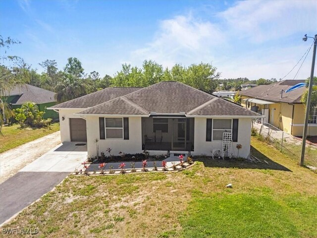 view of front of house with a front yard, fence, stucco siding, concrete driveway, and a garage