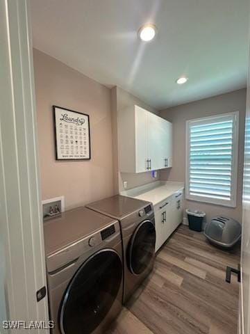 laundry area with cabinet space, washer and dryer, and light wood-style flooring