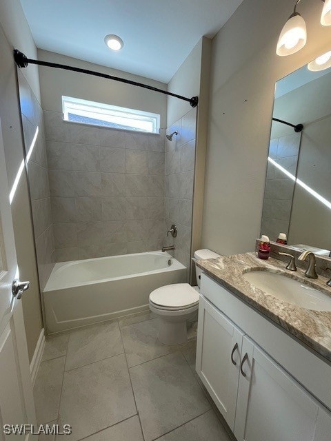 bathroom featuring tile patterned flooring, vanity, washtub / shower combination, and toilet