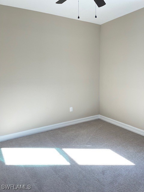 unfurnished room with carpet flooring, baseboards, and a ceiling fan