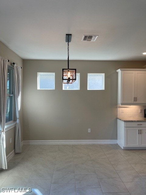 unfurnished dining area with visible vents and baseboards