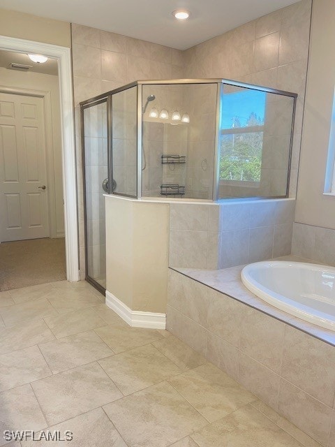 full bath featuring a stall shower and a garden tub