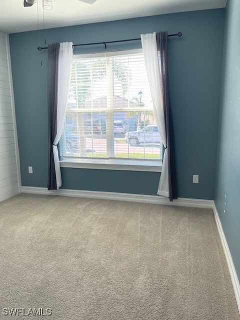 spare room with a ceiling fan, baseboards, and carpet floors