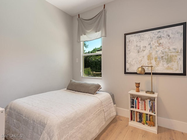 bedroom with baseboards and wood finished floors