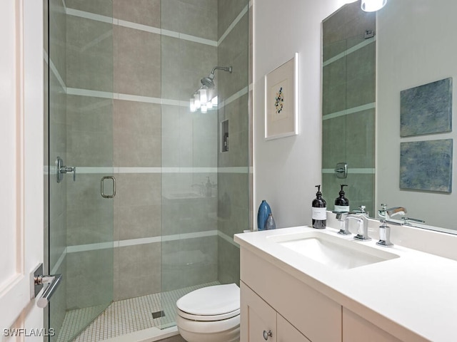 full bathroom featuring a shower stall, vanity, and toilet