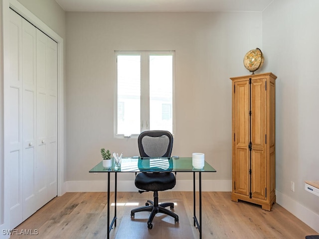 office space with baseboards and light wood-type flooring
