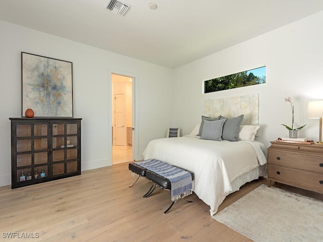 bedroom featuring light wood-type flooring, visible vents, and baseboards