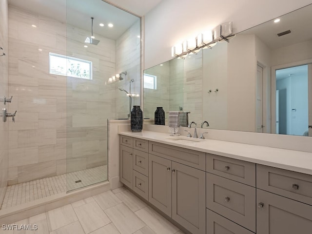 full bathroom featuring marble finish floor, a walk in shower, vanity, and visible vents