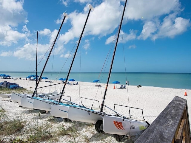 property view of water with a beach view and a dock