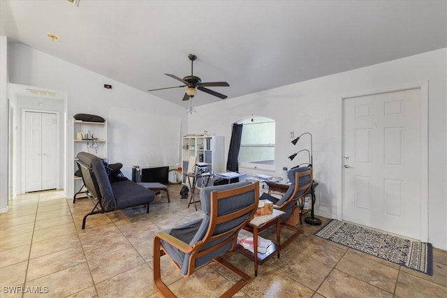 living area with lofted ceiling, light tile patterned floors, and ceiling fan