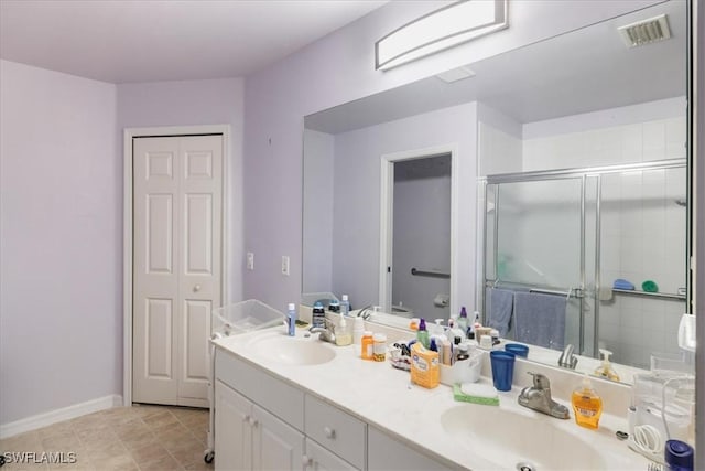 bathroom with double vanity, visible vents, a stall shower, and a sink