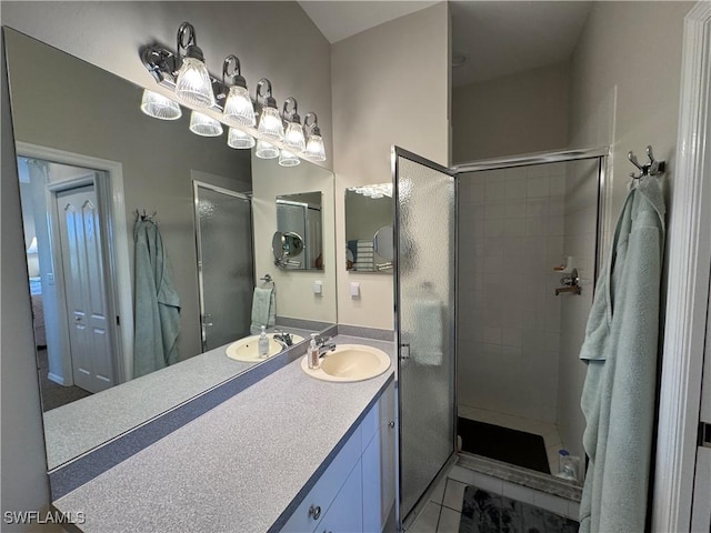 full bathroom featuring tile patterned floors, a stall shower, and vanity