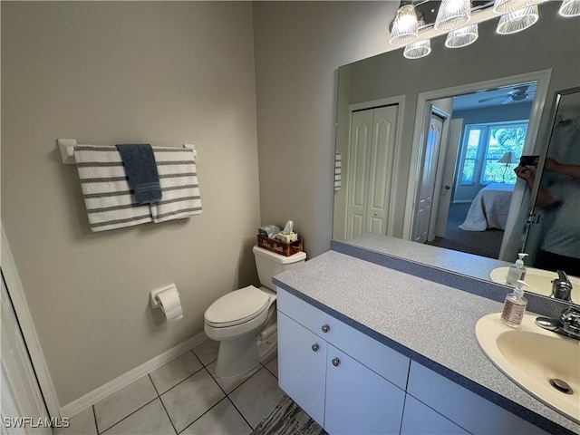 bathroom with toilet, ensuite bath, tile patterned flooring, baseboards, and vanity