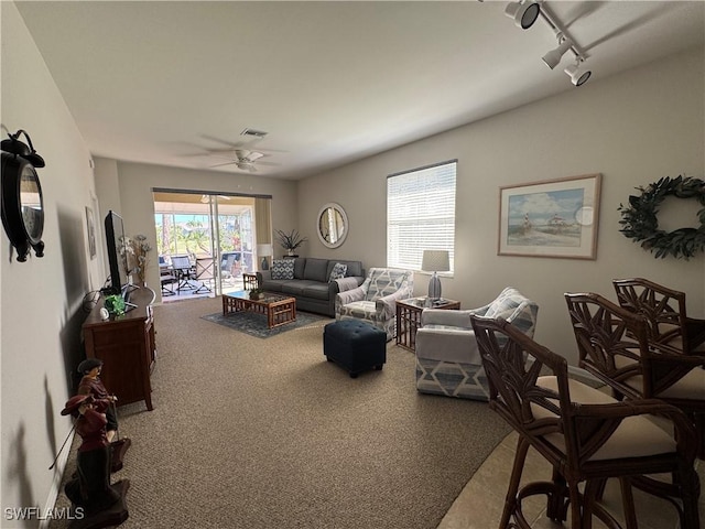 carpeted living room with visible vents, ceiling fan, and rail lighting