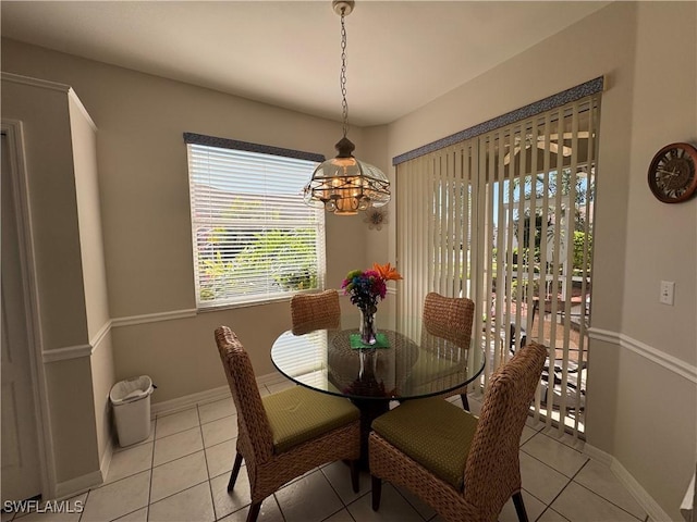 dining space featuring a notable chandelier, baseboards, and light tile patterned floors