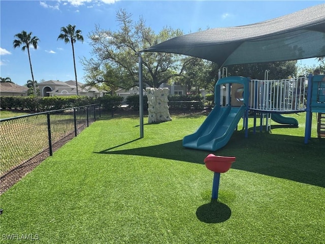 community play area featuring a yard and fence