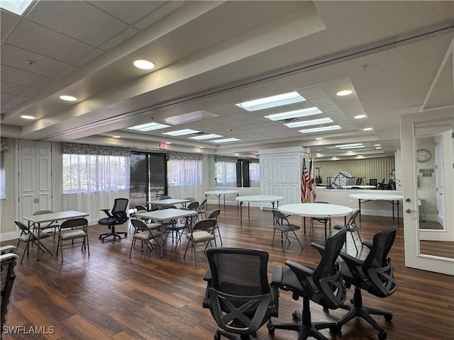 dining space with wood finished floors, baseboards, and a drop ceiling