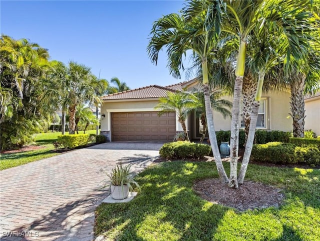13117 Cardeto Ct, Estero, FL 33928 - view of front of property featuring stucco siding, decorative driveway, an attached garage, and a tiled roof