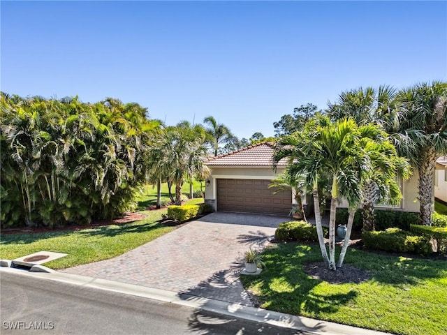 13117 Cardeto Ct, Estero, FL 33928 - view of front facade featuring a tiled roof, decorative driveway, a front lawn, and stucco siding