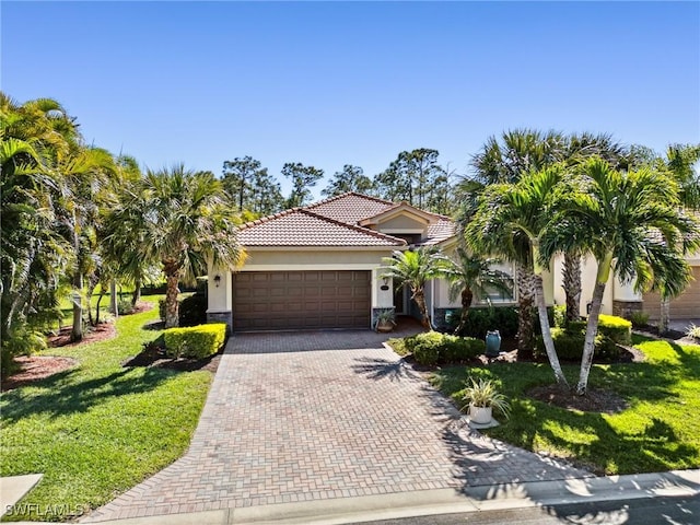 13117 Cardeto Ct, Estero, FL 33928 - view of front of home featuring stucco siding, a front lawn, a tile roof, decorative driveway, and a garage