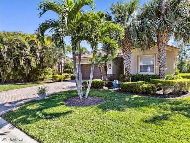 13117 Cardeto Ct, Estero, FL 33928 - obstructed view of property featuring stucco siding, an attached garage, decorative driveway, and a front yard